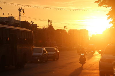 Cars on street in city at sunset