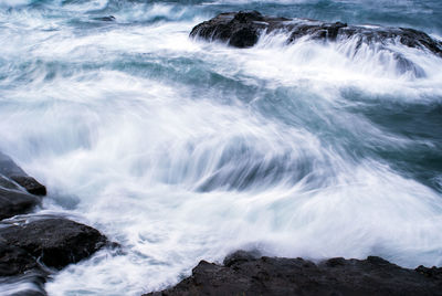 Scenic view of sea waves splashing on rocks