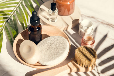 Set of skin care and wellness products - serum bottle, exfoliation brush and soap, cream and sponge