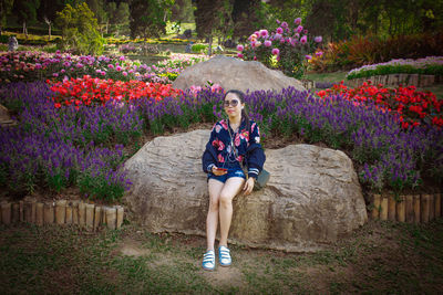 Full length portrait of woman with purple flowers