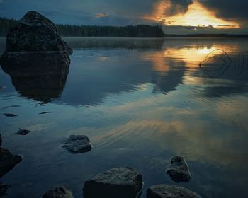 Scenic view of lake against sky at sunset