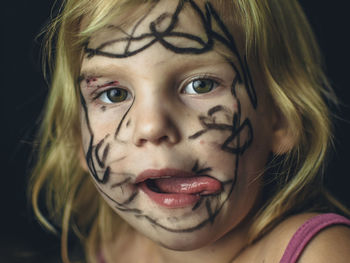 Close-up portrait of messy girl against black background
