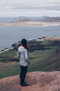 Rear view of woman standing on shore