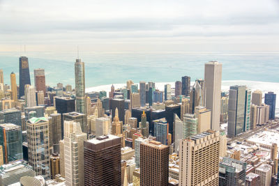 Aerial view of modern skyscrapers in city by frozen lake michigan