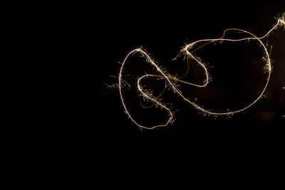 Close-up of illuminated lighting equipment against black background