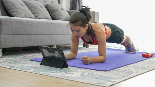 Side view of woman using laptop at home