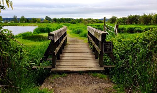 Wooden gate on field against sky