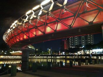 Low angle view of illuminated footbridge against sky at night