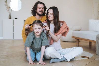 Young happy family with child girl having fun in living room at the home