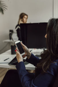 Woman using cell phone in office