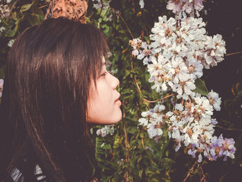 Side view of woman looking at flowering plants