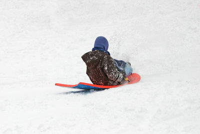 Woman tobogganing on snow