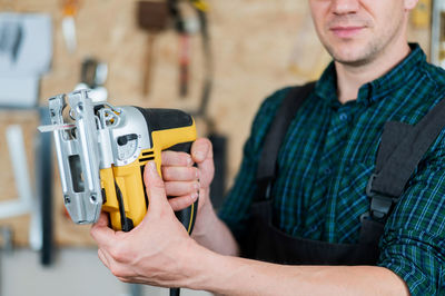 Midsection of man holding camera