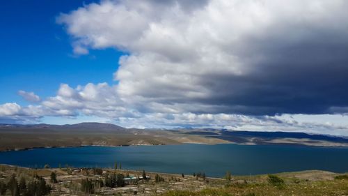 Scenic view of sea and mountains against cloudy sky