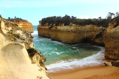 Rock formations by sea against sky