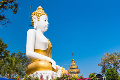 Low angle view of statue against blue sky