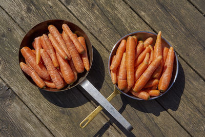 Directly above shot of carrots in frying pans on table