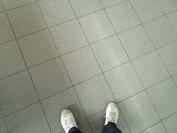 Low section of man standing on tiled floor