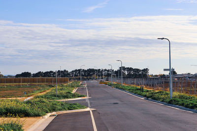 Street by road against sky in city