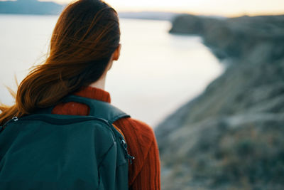 Rear view of woman looking at sea against sky