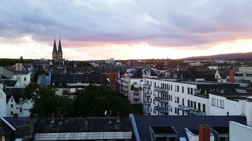 Buildings against cloudy sky at sunset