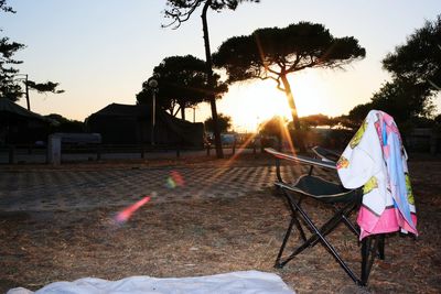 Umbrellas on footpath against clear sky at sunset