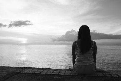 Rear view of woman looking at sea against sky