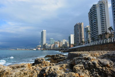 Modern buildings by sea against sky