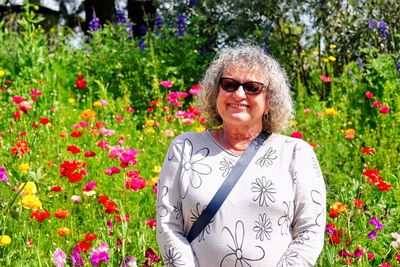 Young woman standing amidst flowering plants