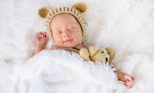 Cute baby girl sleeping on bed at home