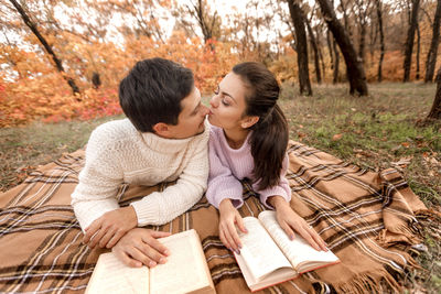 Couple with books kissing at park