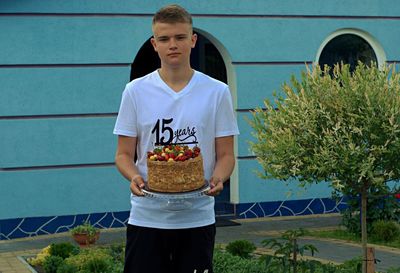 Full length of boy holding plant