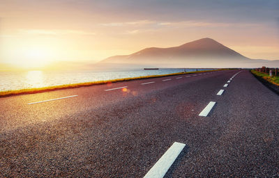 Asphalt road along the sea at sunset.