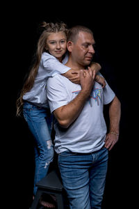 Full length of couple standing against black background