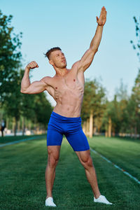 Shirtless man exercising on field