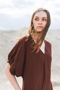 Portrait of beautiful young woman standing on beach