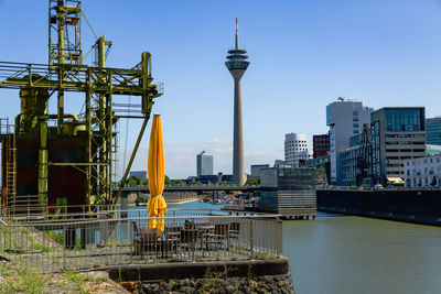 Buildings by river against sky in city