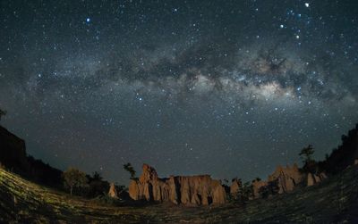 Scenic view of rock formation against sky at night