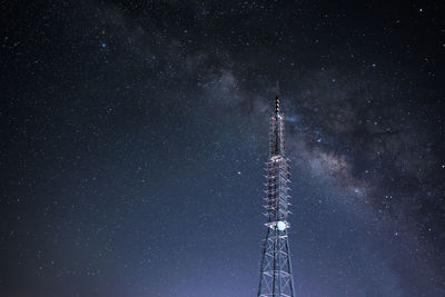 Low angle view of communications tower against galaxy