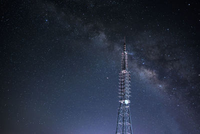 Low angle view of communications tower against sky at night