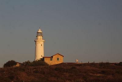 Lighthouse amidst buildings against sky