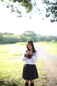 Portrait of woman standing on field