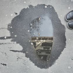 High angle view of building reflected on puddle