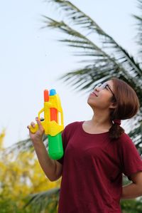 Portrait of a girl holding toy while standing outdoors