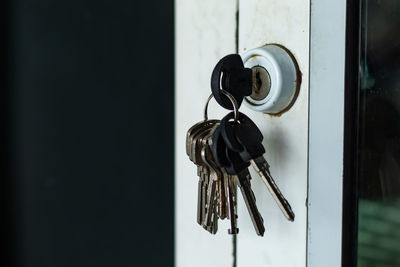 Close-up of keys hanging on door at home