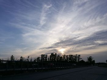 Road in city against sky during sunset