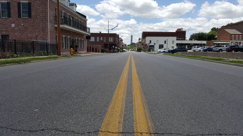 Empty road with buildings in background