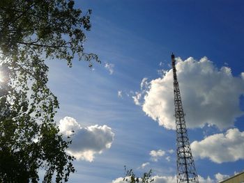 Low angle view of communications tower against cloudy sky