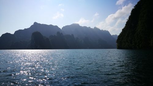 Scenic view of sea and mountains against sky