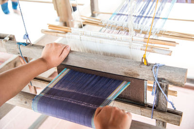 Close-up of person working on handloom